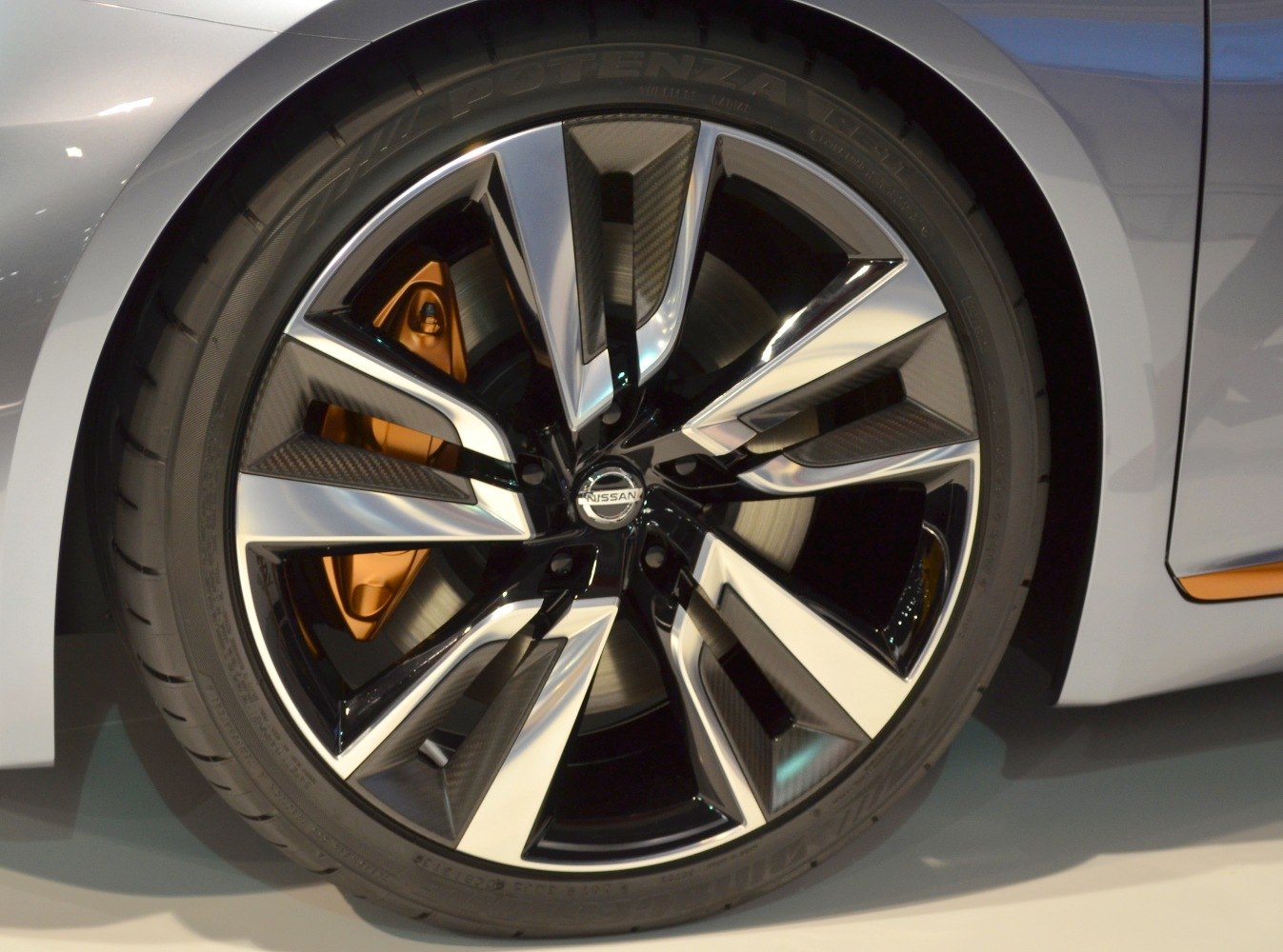 Close-up of alloy wheel with orange brake caliper