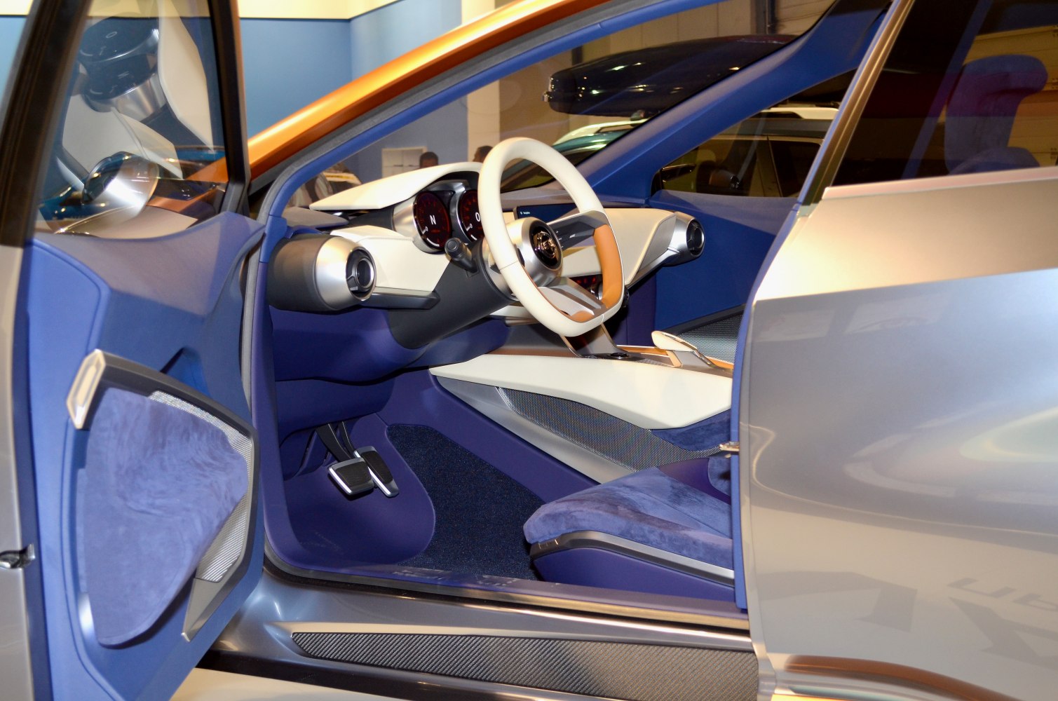 Futuristic interior with unique steering wheel and circular air vents.