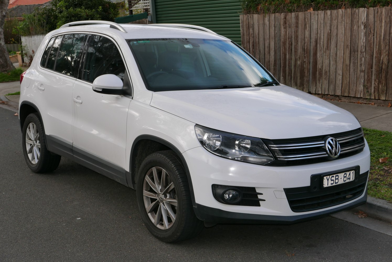 White mid-size SUV front side view with roof rails and alloy wheels