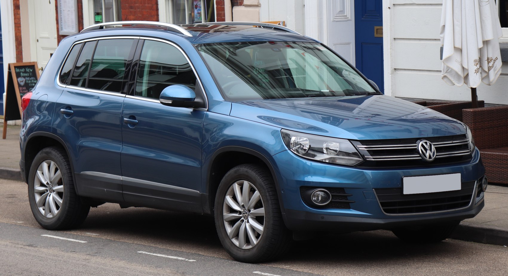 Front and side view of blue SUV with alloy wheels and chrome grille
