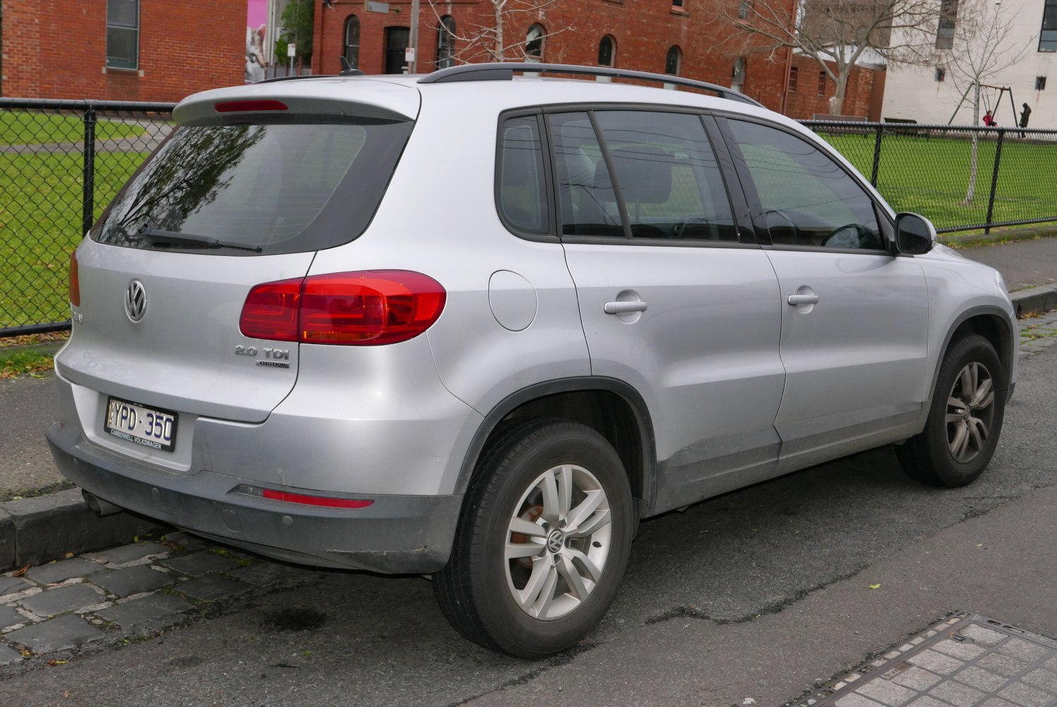Rear and side view of an SUV with tinted windows and roof rails