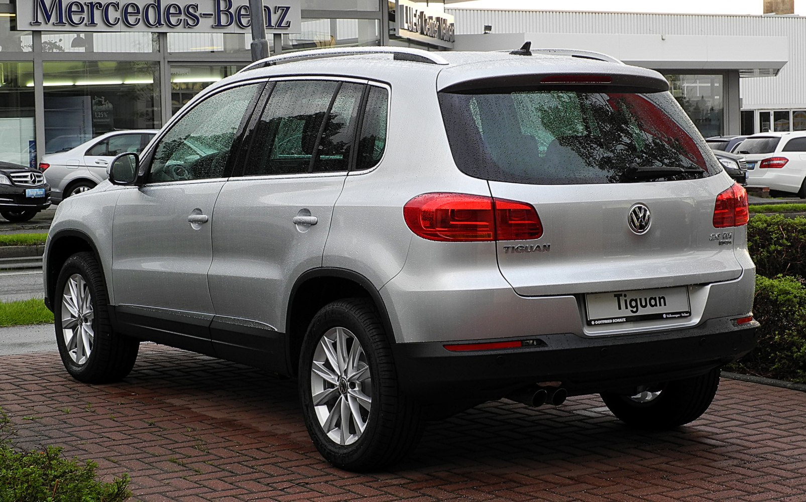 Rear and side view of a silver compact SUV with red taillights and alloy wheels