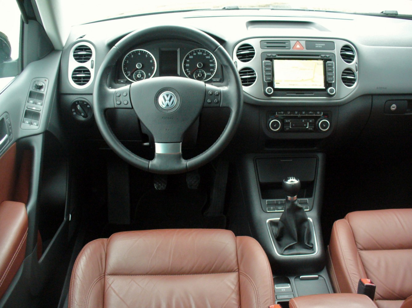 Steering wheel and dashboard with leather seats in car cabin