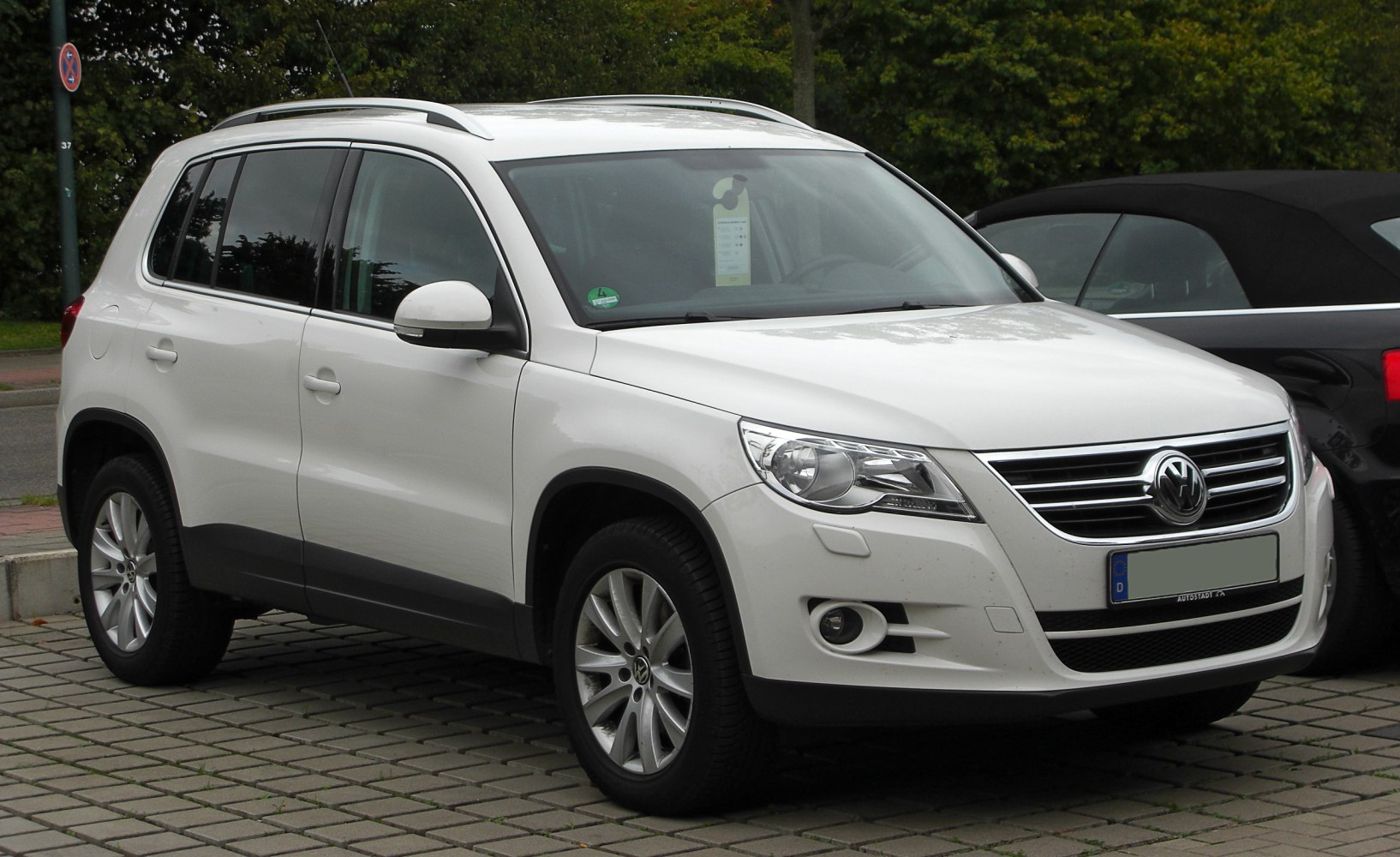 Front and side view of an SUV featuring headlights and distinct grille.