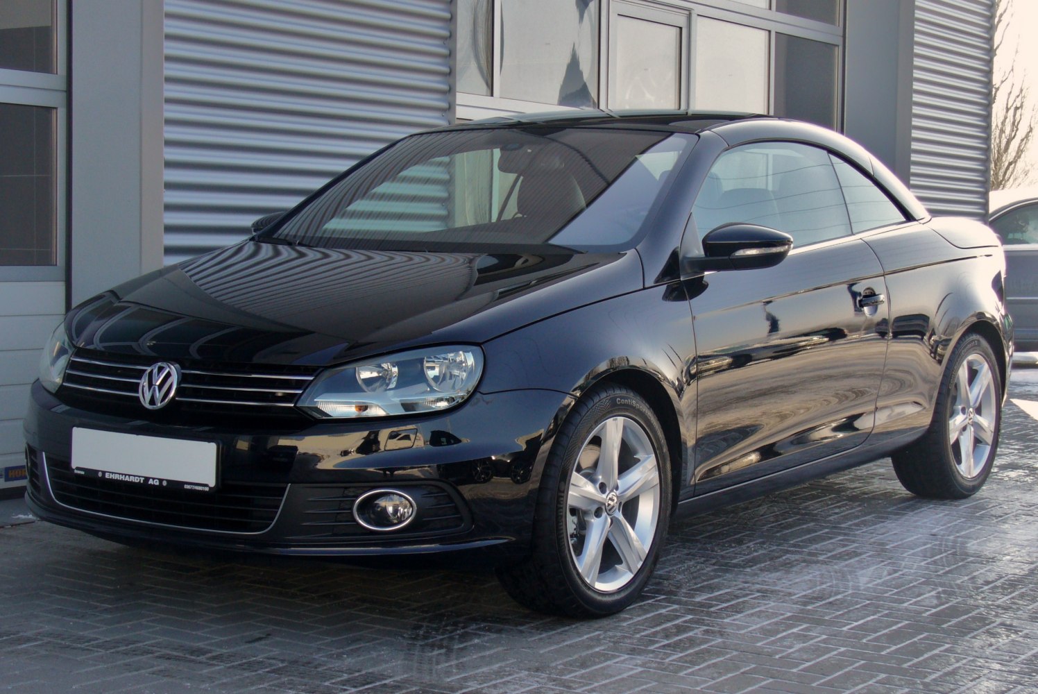 Front-side view of black convertible with alloy wheels and sleek design