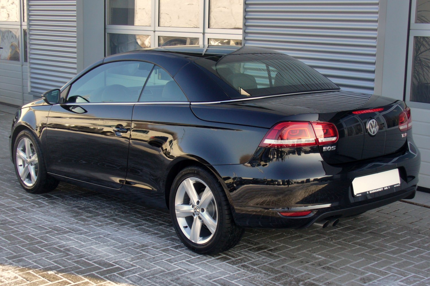Rear side view of black convertible with distinctive taillights and alloy wheels