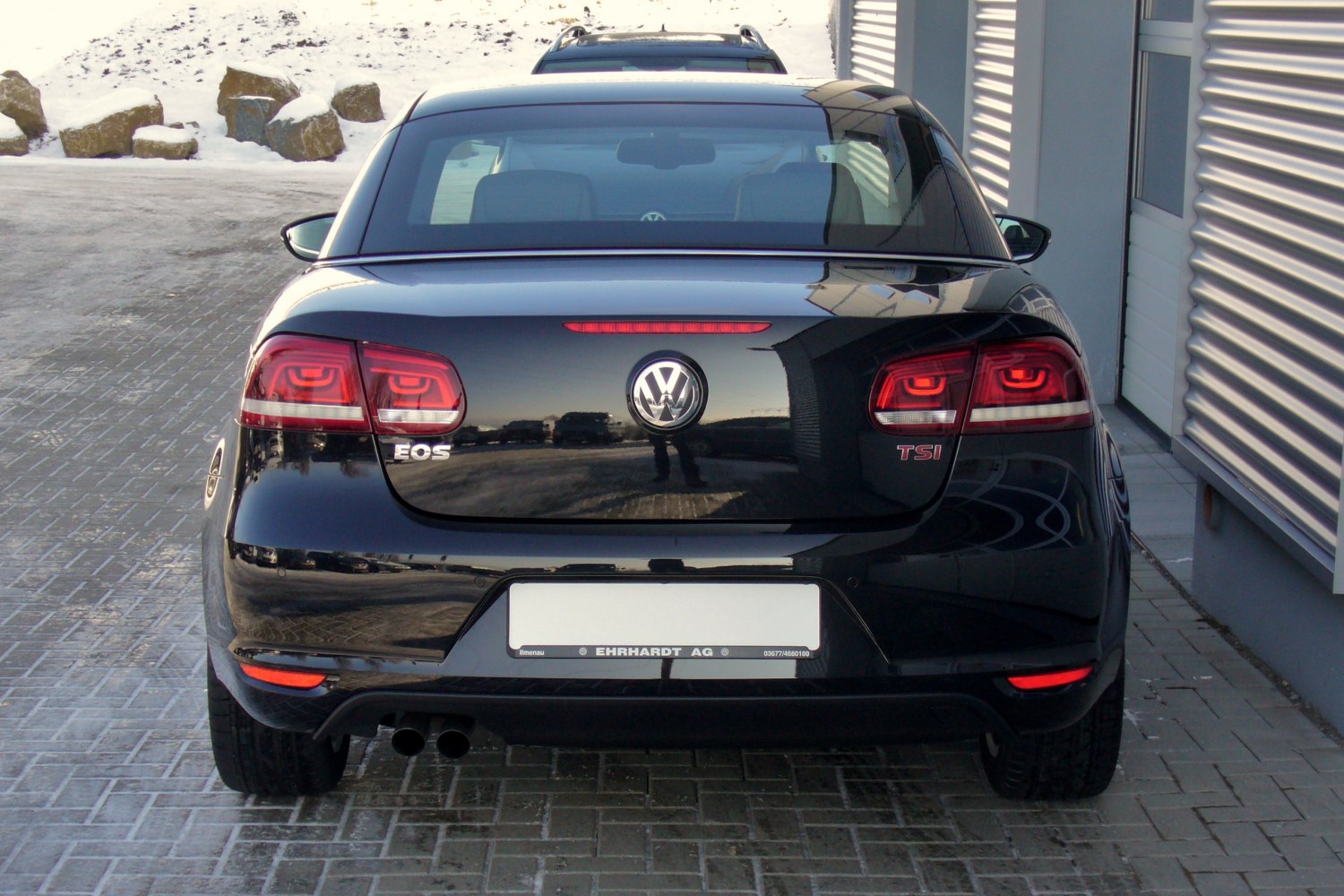 LED tail lights and dual exhaust at rear of black hardtop convertible