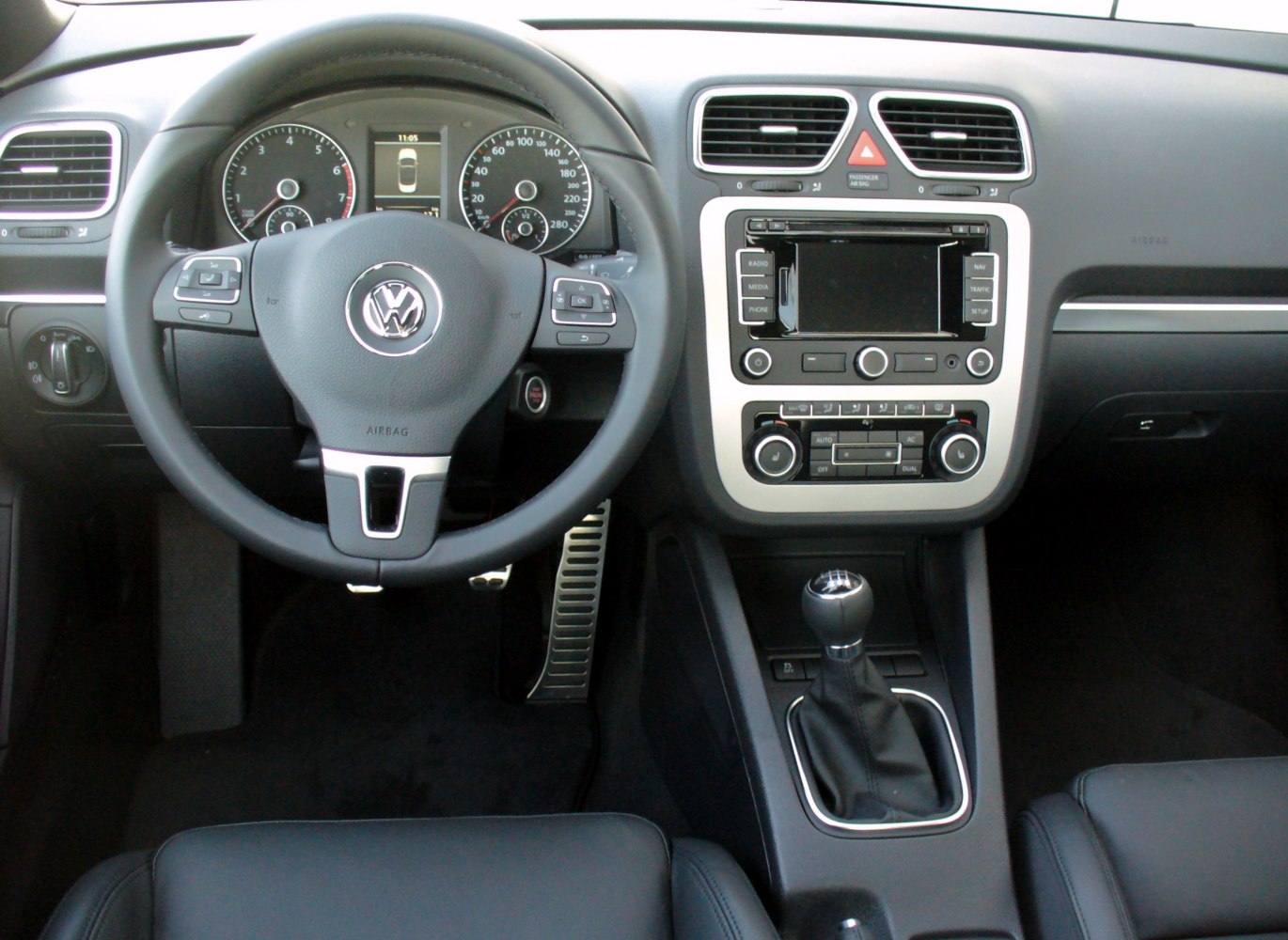 Dashboard, steering wheel with controls, manual gear shift
