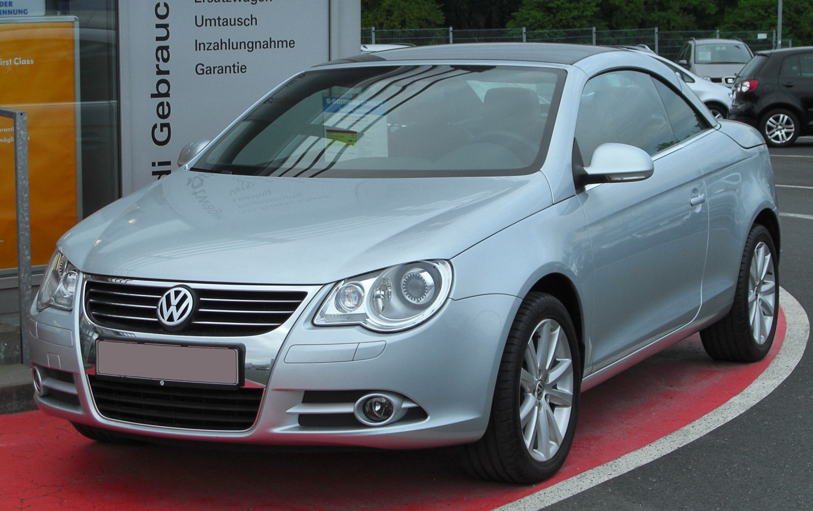 Silver car front view with chrome grille and alloy wheels