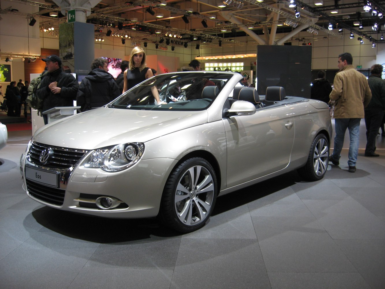 Silver convertible with retractable hardtop, showcased indoors.