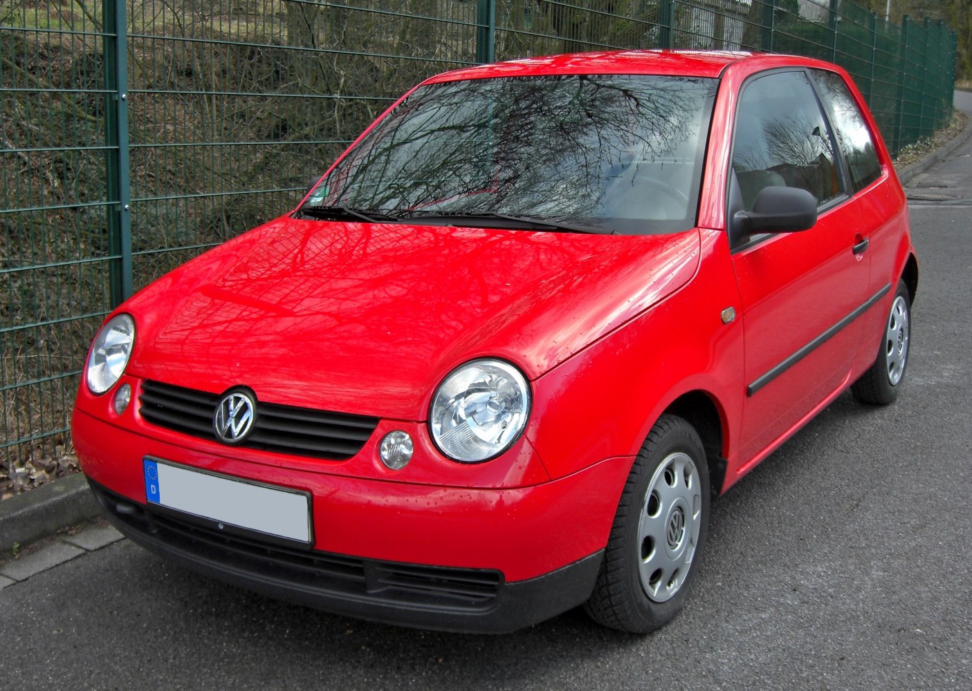 Red compact hatchback with round headlights and black grille