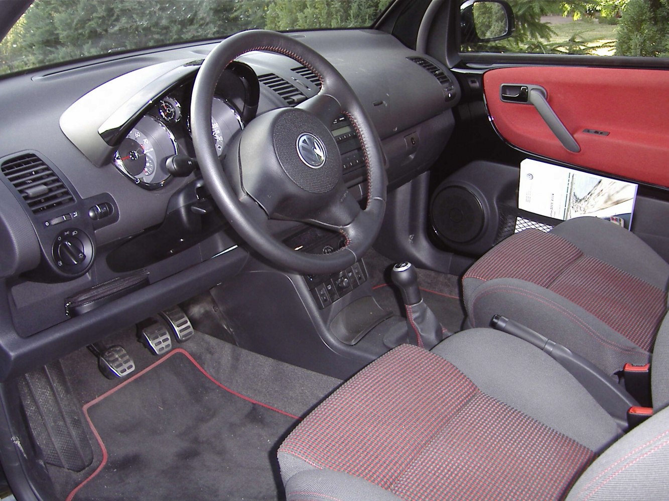 Dashboard, steering wheel, manual gearstick, patterned seats