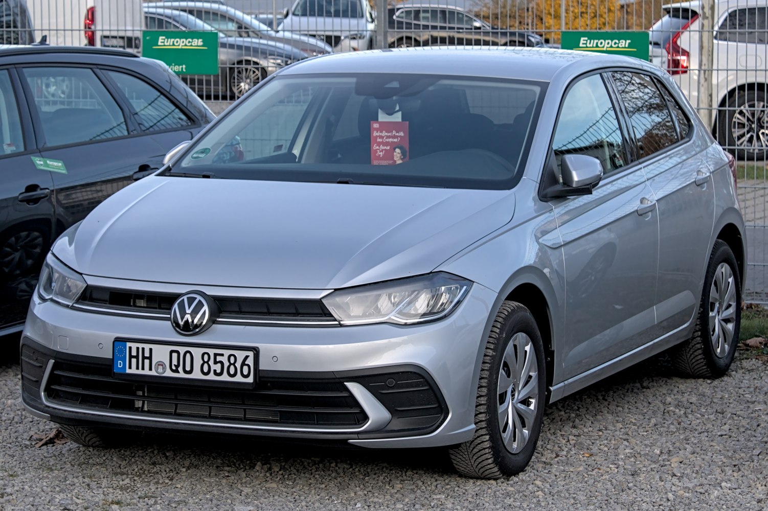 Silver hatchback front side view with distinct headlight and grille.