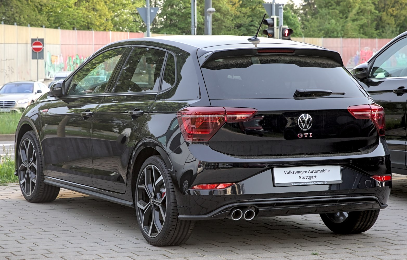 Rear and side view of a sporty hatchback with dual exhaust and alloy wheels