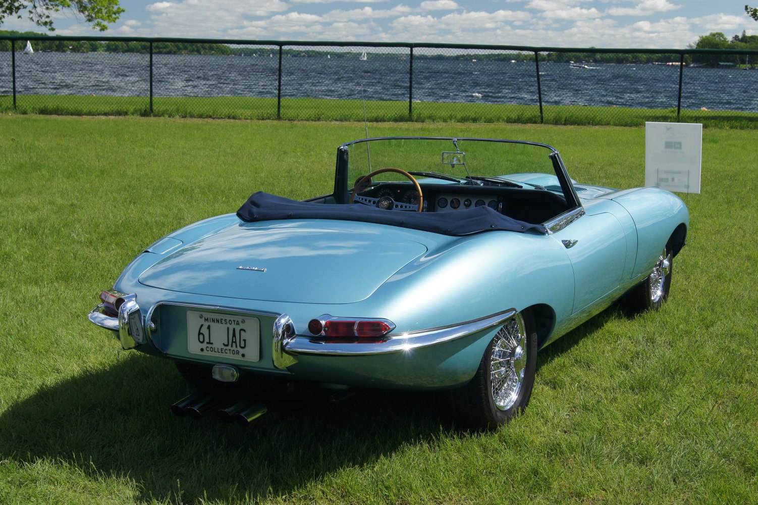Rear view of blue convertible with chrome bumpers and wire-spoke wheels