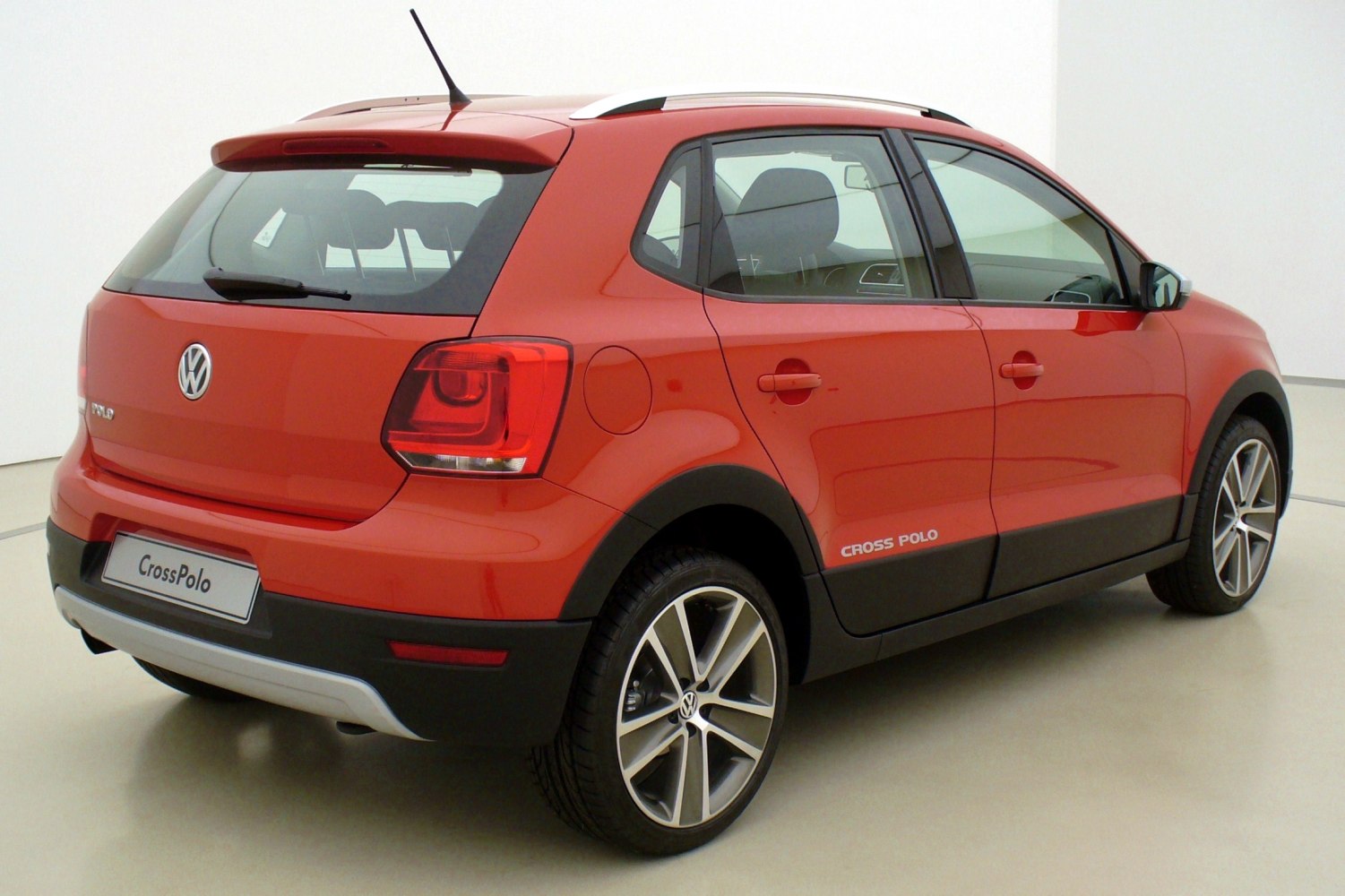 Red compact five-door hatchback with roof rails and alloy wheels
