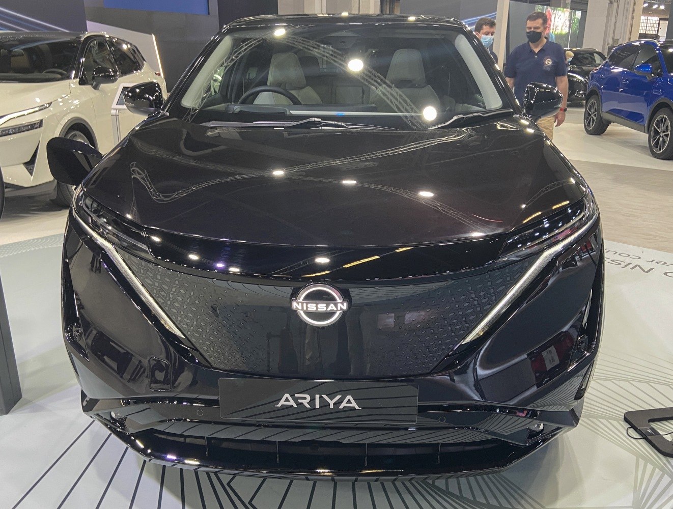 Front view of an electric SUV with sleek LED headlights and futuristic grille
