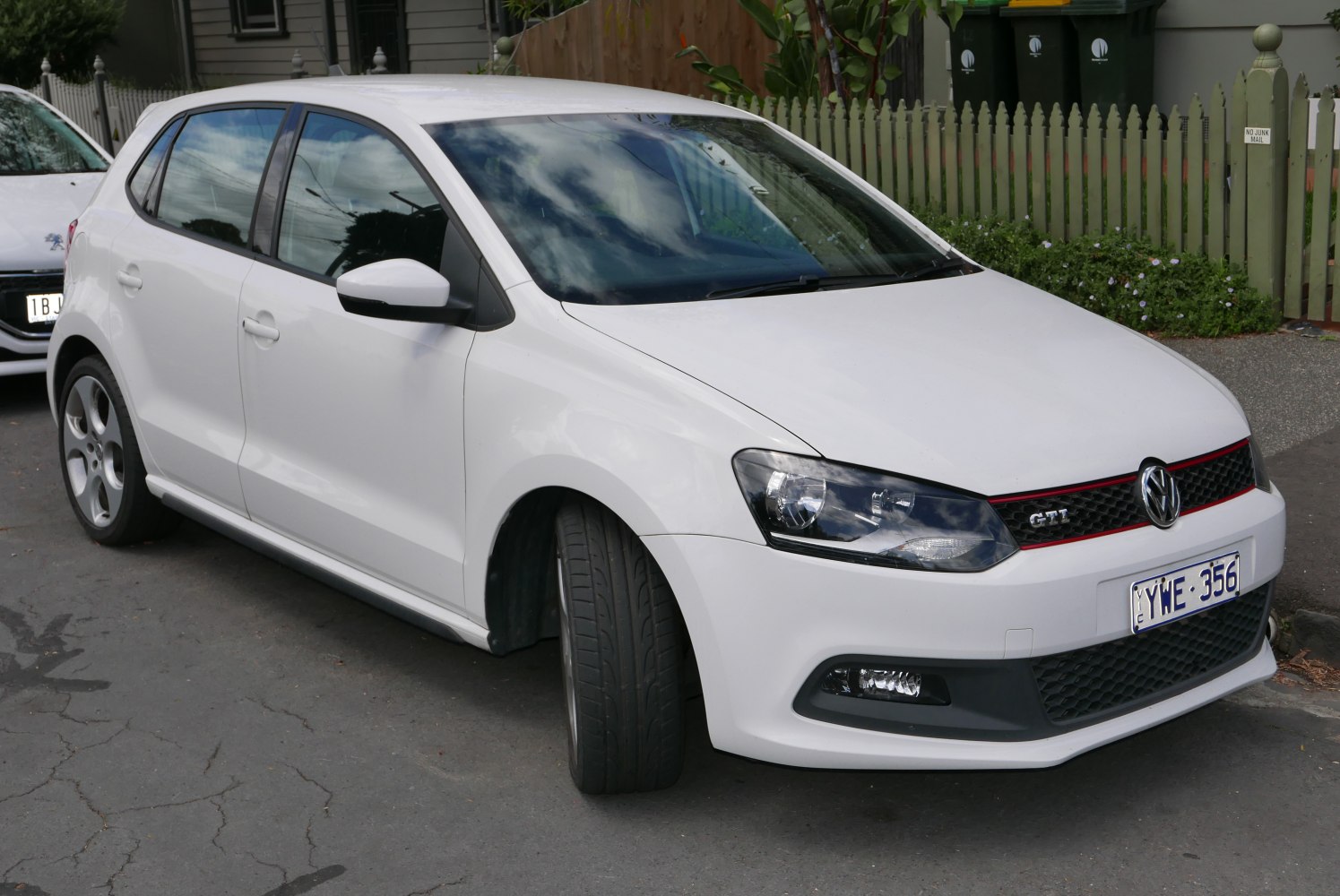 White 5-door hatchback with red-accented grille and sporty front design