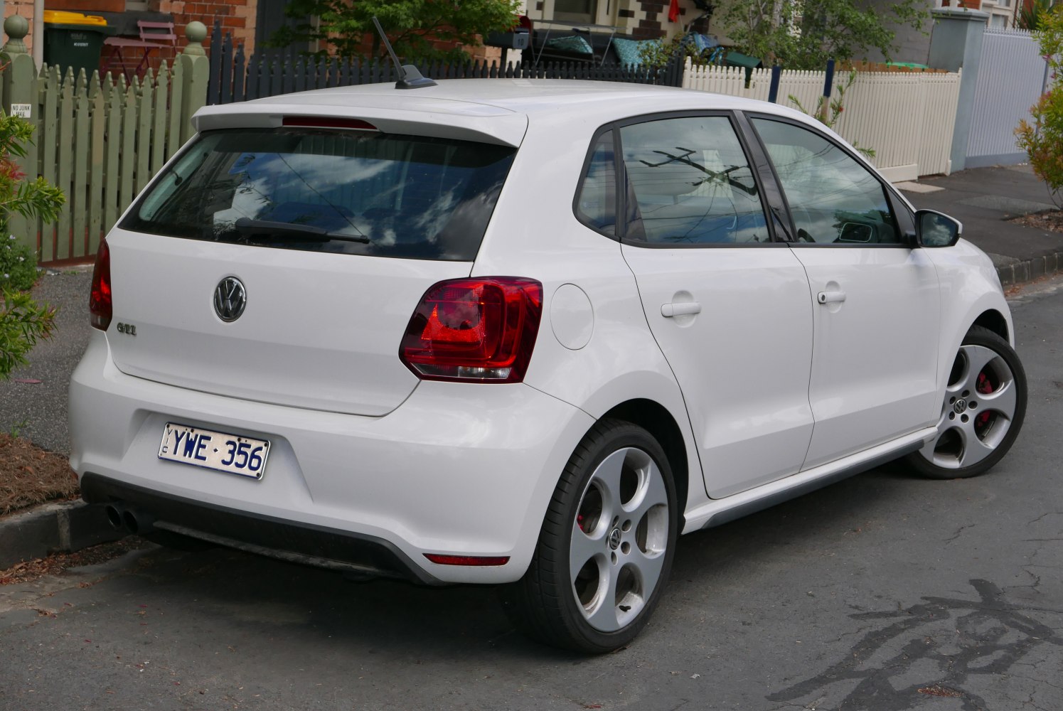 Rear and side view of white 5-door hatchback with sporty wheels and rear spoiler