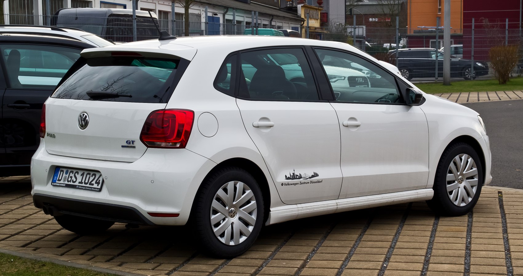 Rear-side view of a white 5-door hatchback with distinctive taillights and wheels