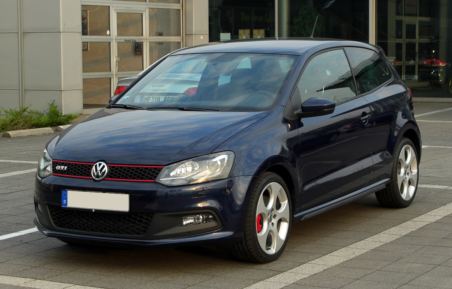 Front and side view with headlights, grille, and sporty alloy wheels