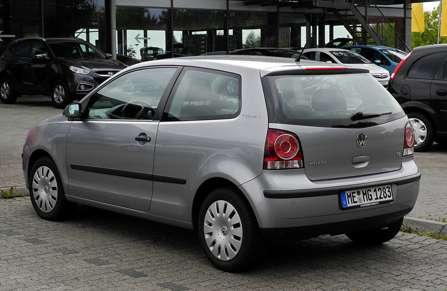 Rear side view of a three-door hatchback with round taillights.