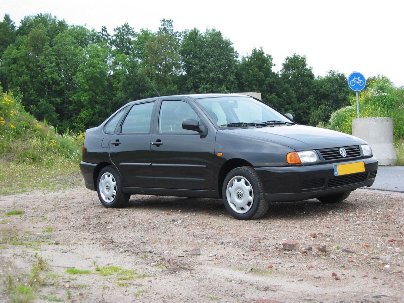Compact hatchback side profile with four doors and Volkswagen emblem hubcaps