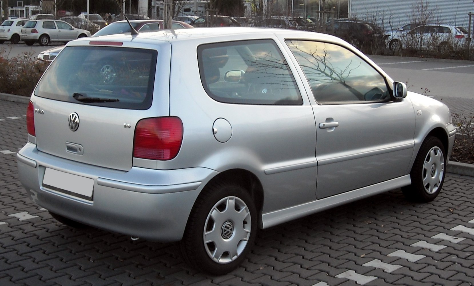Silver small hatchback rear and side view with taillights and wheel covers.