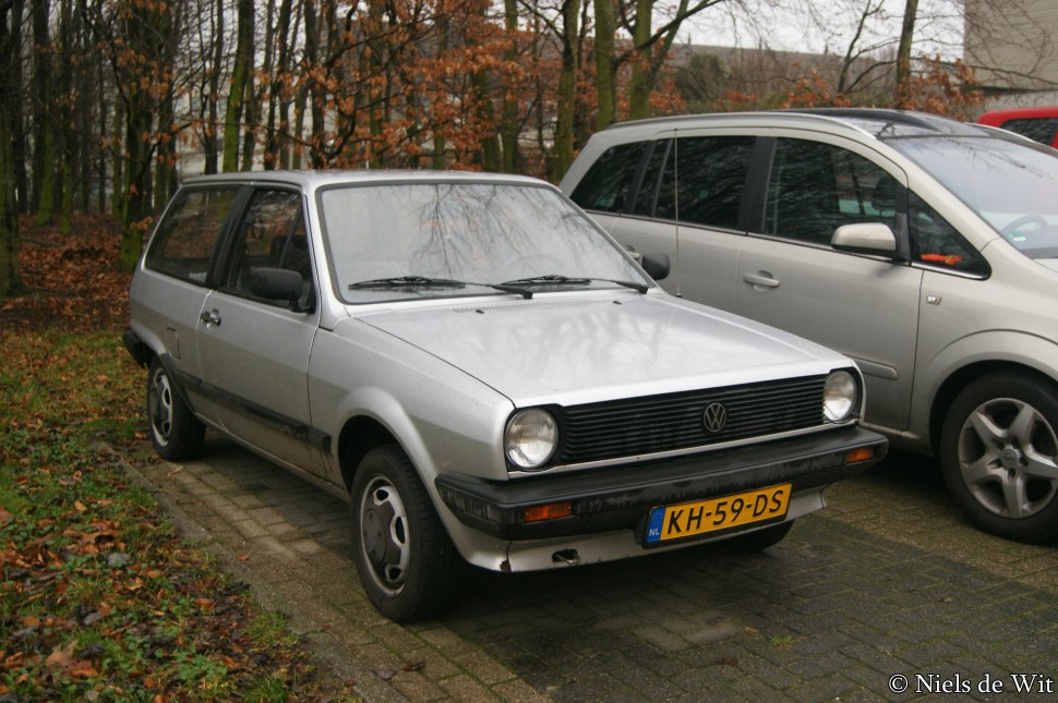 Front side view of a vintage hatchback with round headlights and boxy design