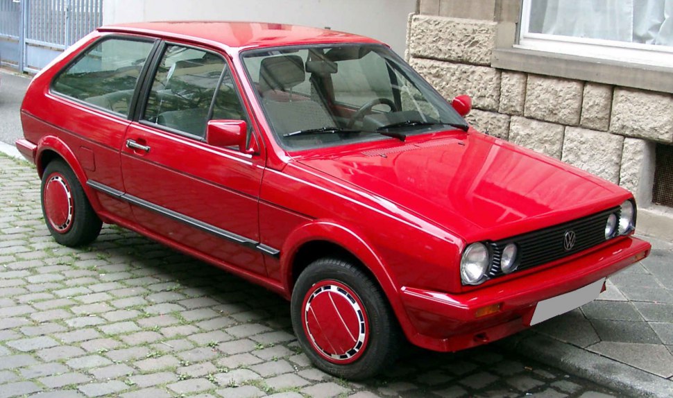 Red vintage two-door hatchback with round headlights and sporty design