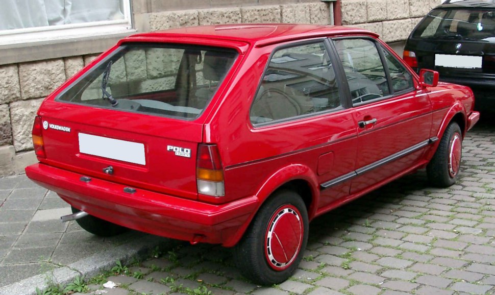 Red classic hatchback with distinctive rear-side view and vintage wheel covers