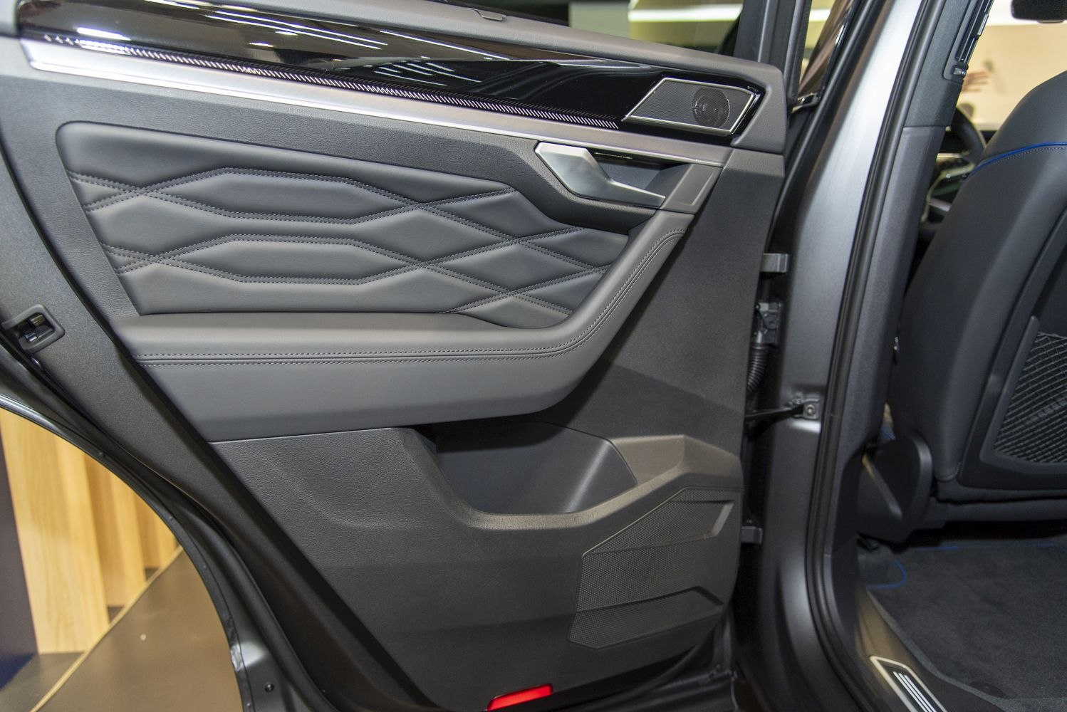 Rear door interior panel with stitched leather and integrated handle