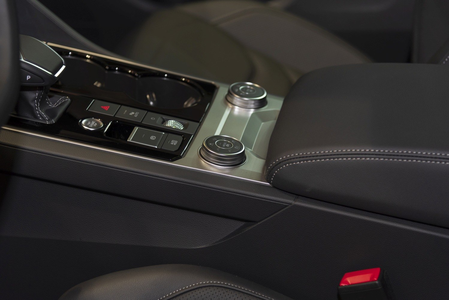 Center console with gear selector, control knobs, and leather armrest