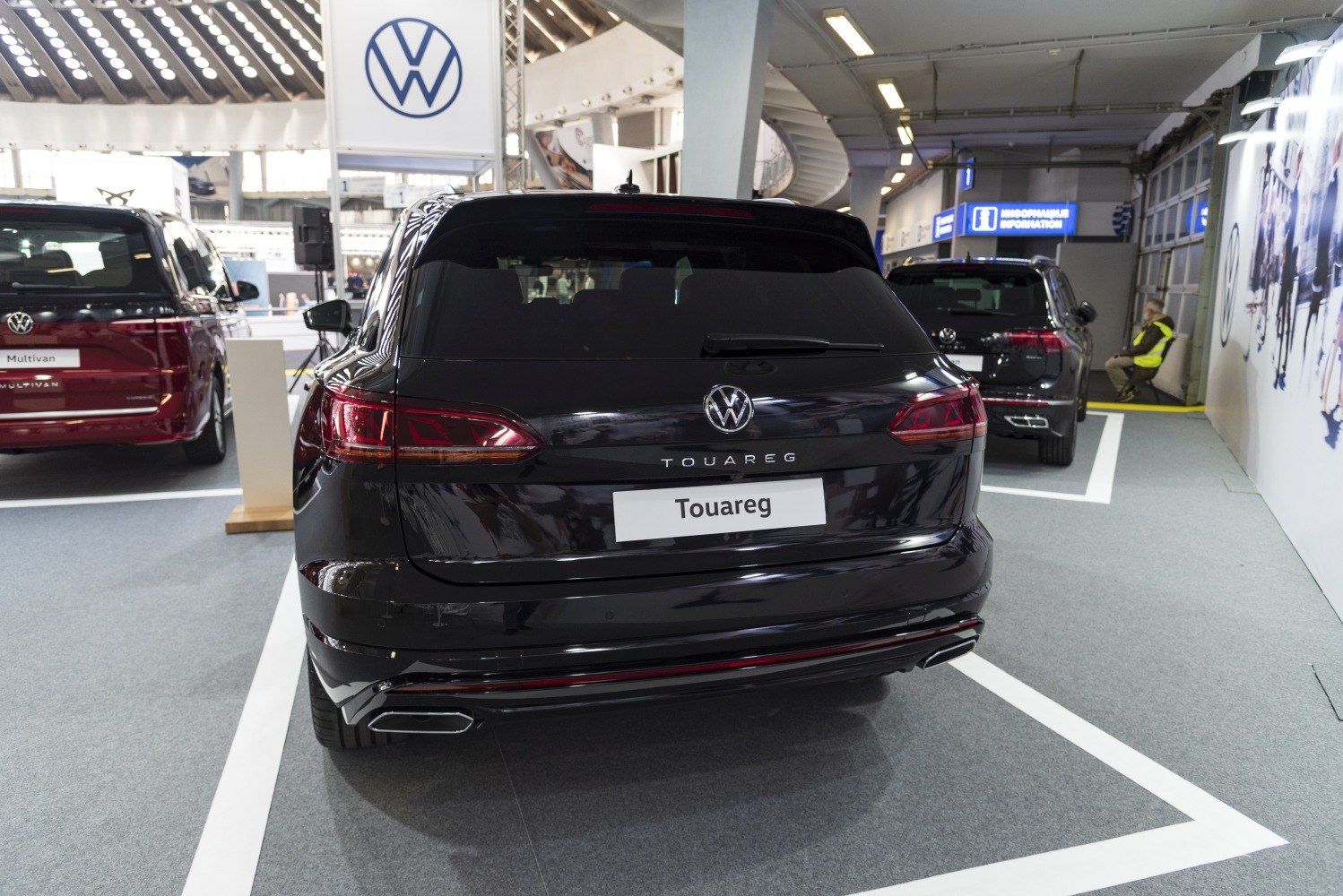 Rear view of a black SUV with tail lights, VW logo, and dual exhaust