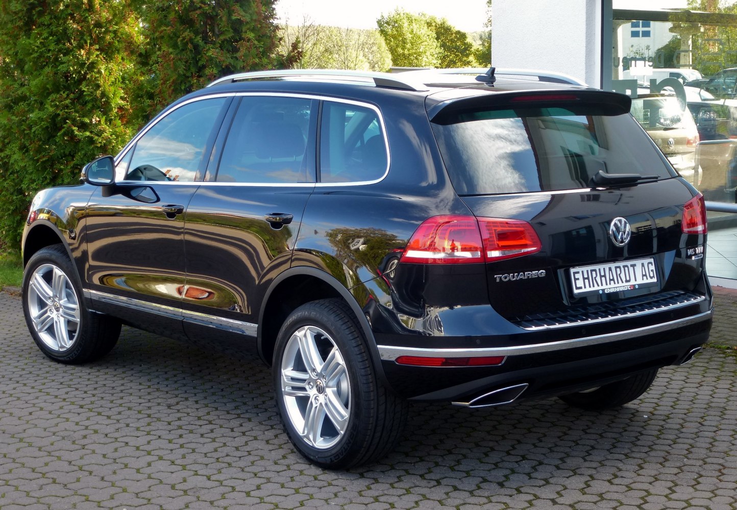 Upscale SUV rear side, alloy wheels, dual exhaust, roof rails