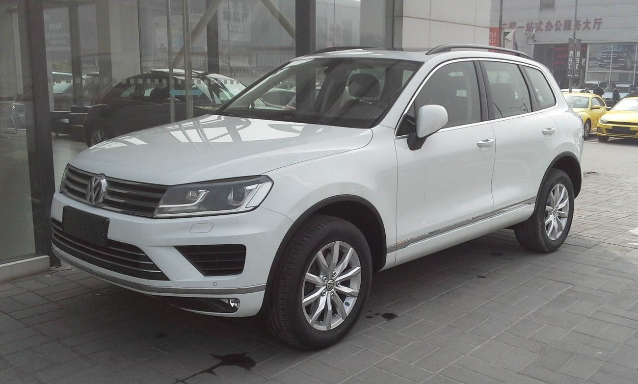 Front side view of a white SUV with distinct grille and headlight design.