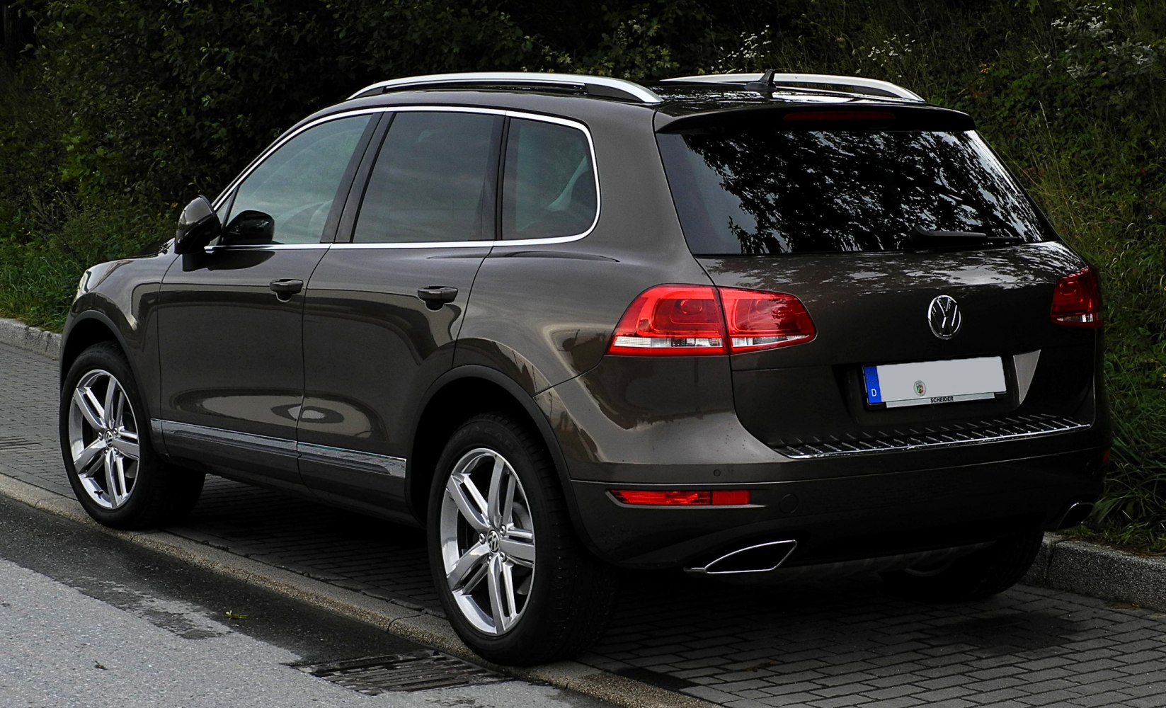 Rear side view of an SUV with chrome roof rails and LED tail lights