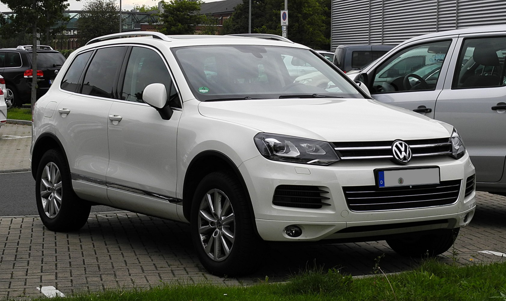 White mid-size SUV front side with alloy wheels and roof rails