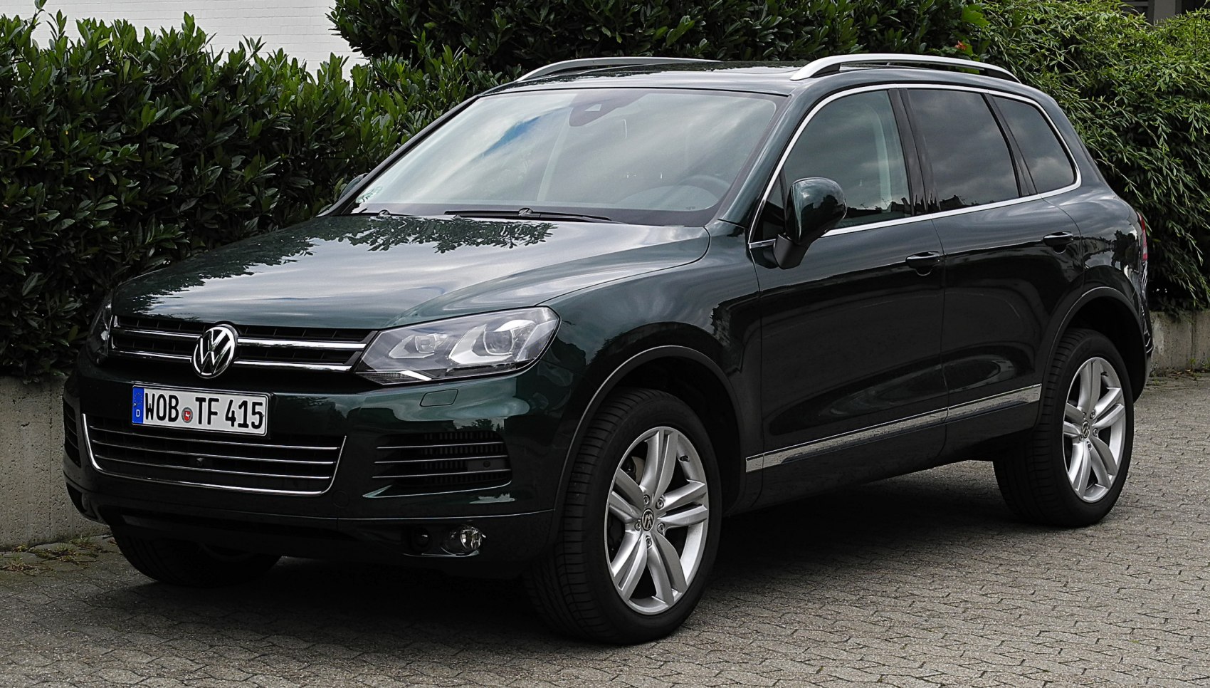 SUV front side view with grille, headlights, alloy wheels, and roof rails
