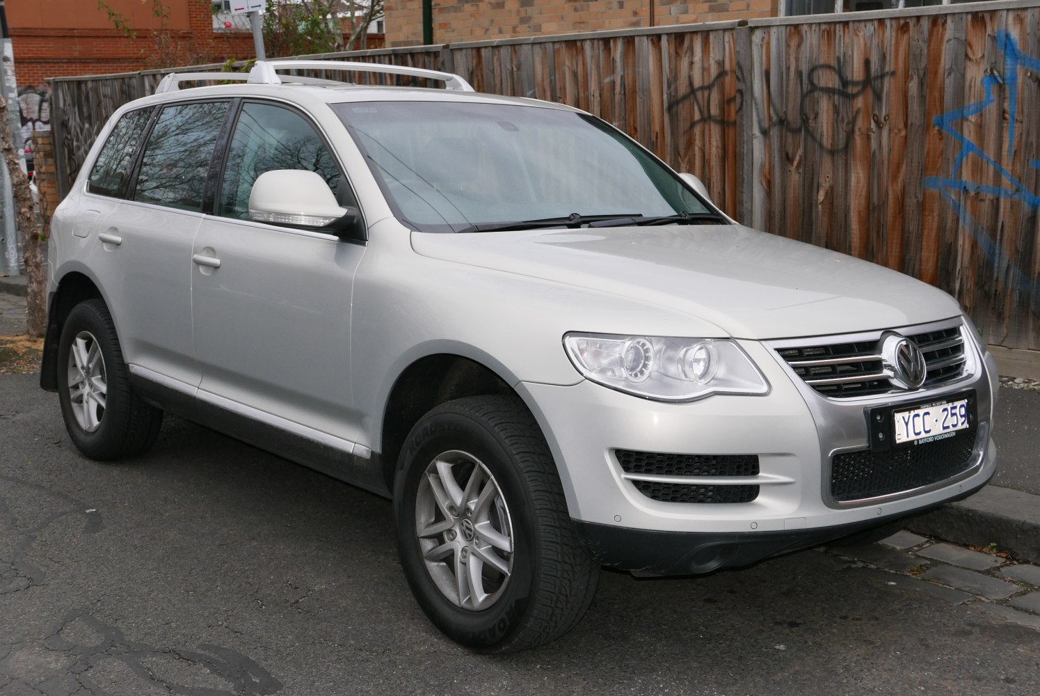 Front-side view of SUV with headlights, grille, alloy wheels