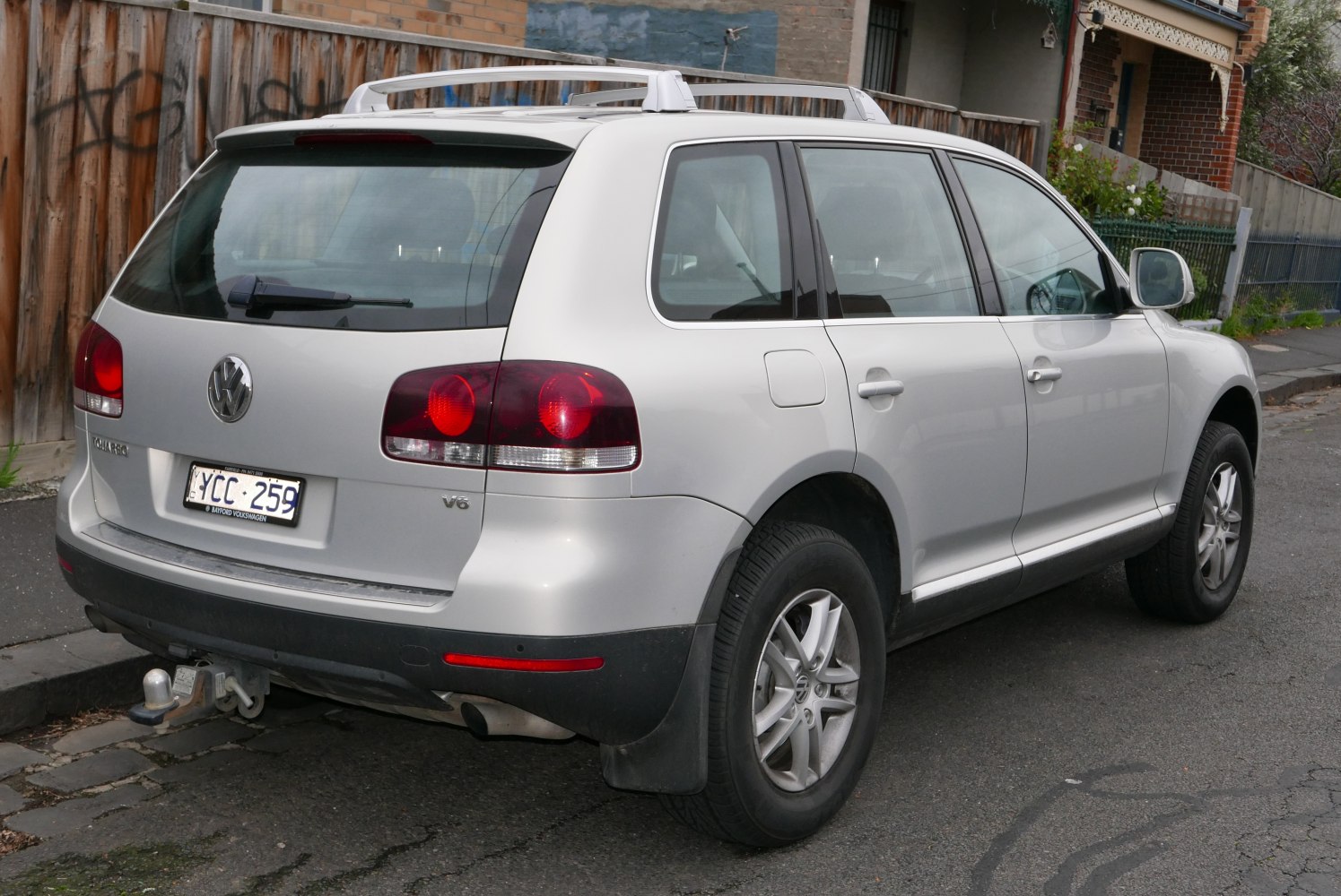 Rear angle showing roof rails, V6 badge, and tow hitch