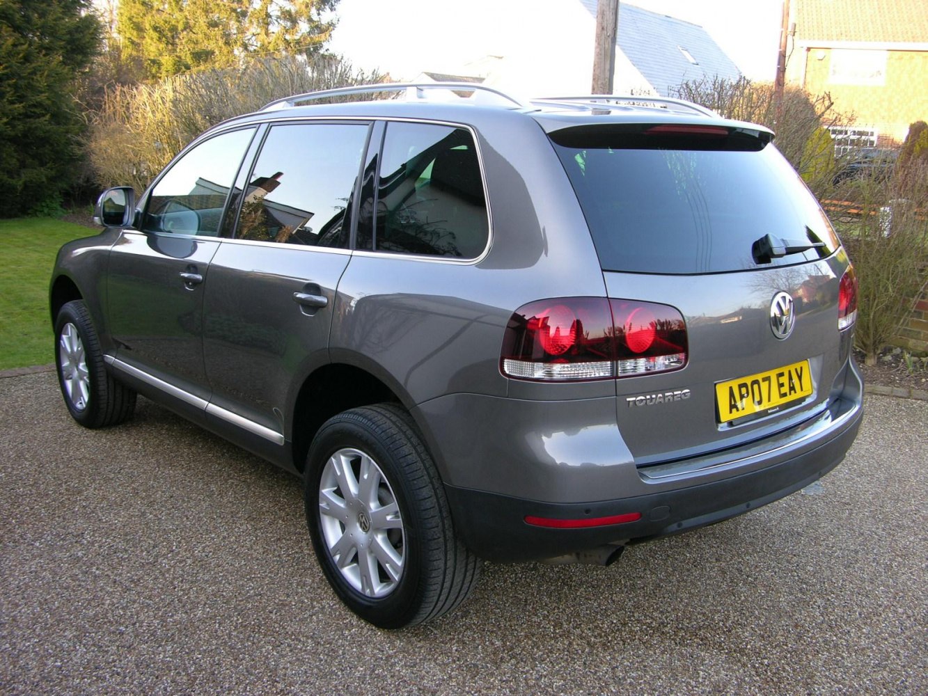 Gray SUV rear side with distinctive taillights and roof rails