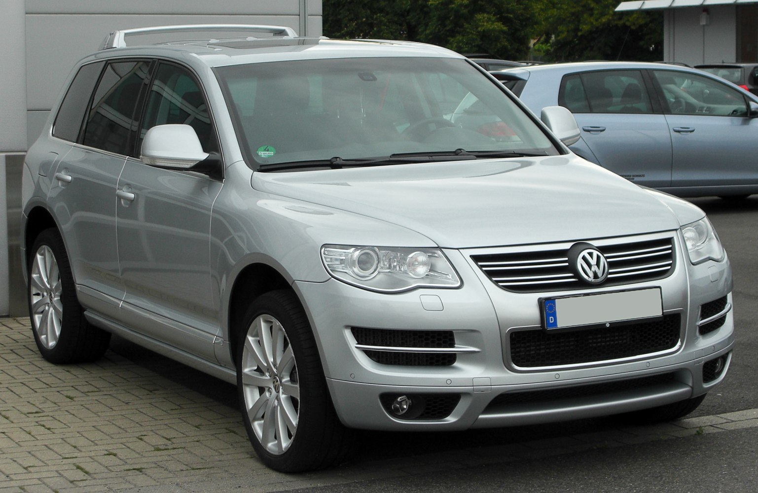 Silver mid-size SUV front and side with grille, headlights, and alloy wheels