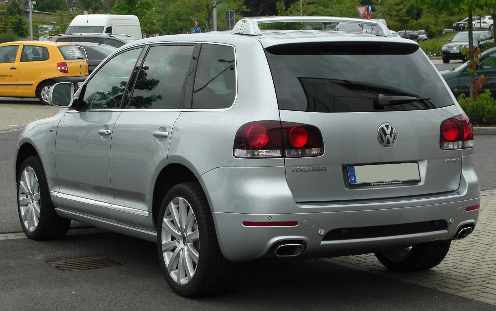 SUV rear view with dual exhaust, alloy wheels, tinted windows