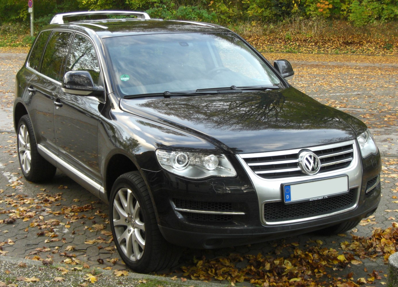 Front grille, headlights, side profile, roof rails view of midsize SUV