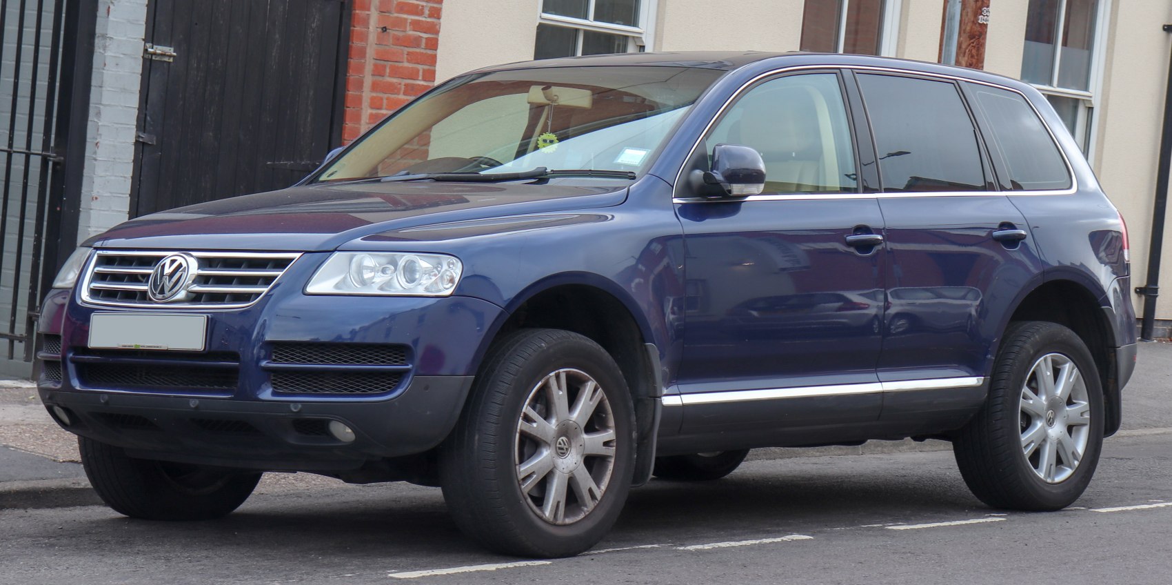 Front and side profile of blue mid-2000s SUV with alloy wheels