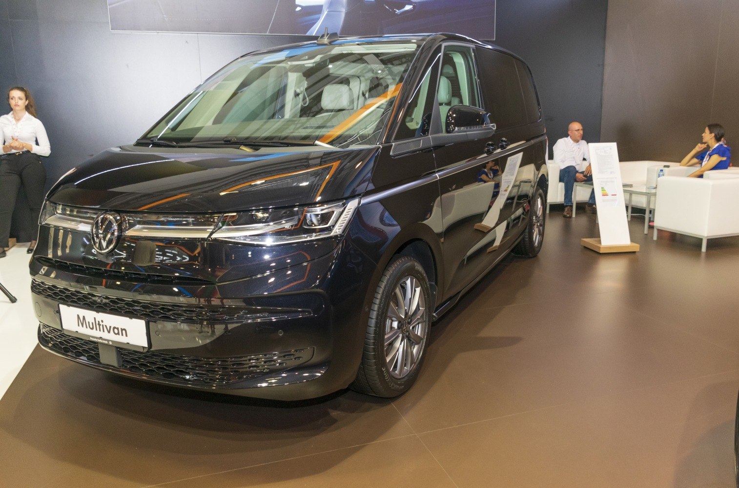 Front and side view of a black modern van with sleek headlights and alloy wheels
