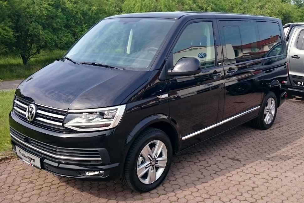 Front-side view of a black passenger van with sliding door and distinctive headlights