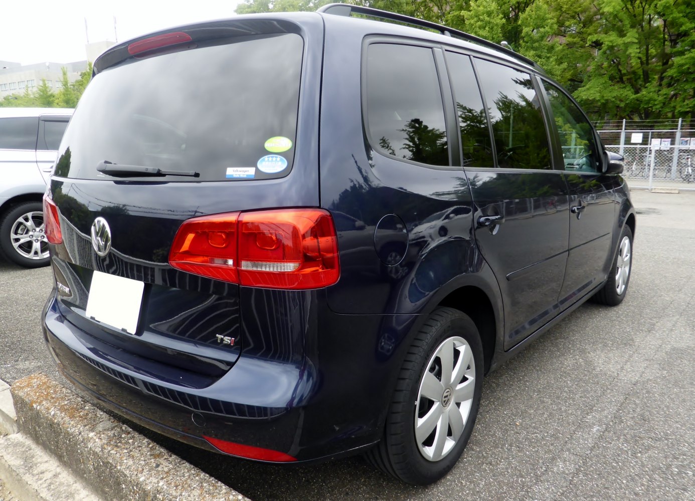 Compact MPV rear and side view with red taillights and tinted windows