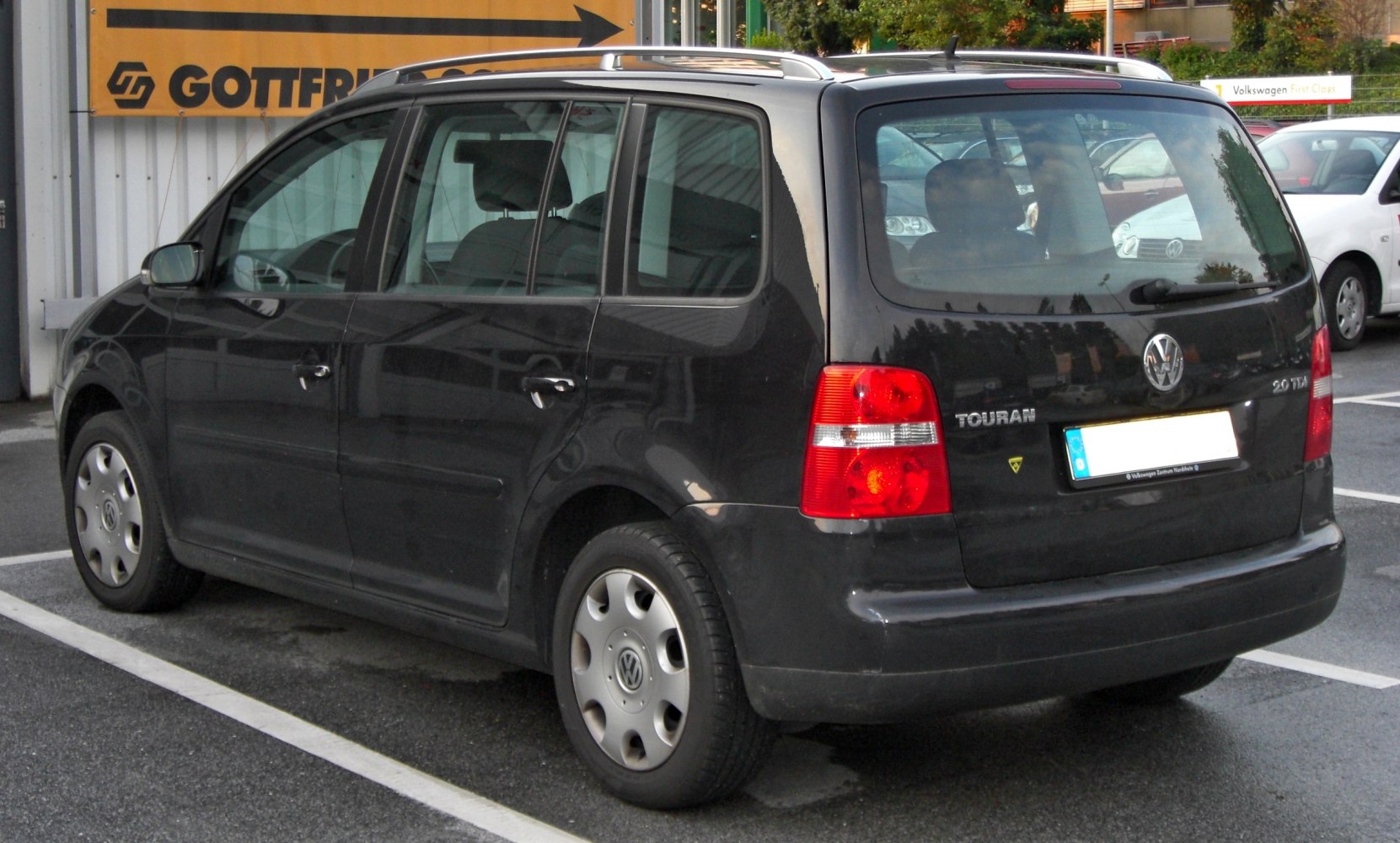 Rear side view of compact MPV with tail lights and roof rails